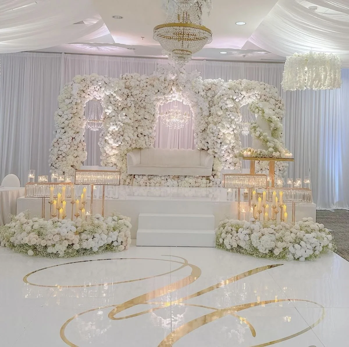 Elegant gold monogram at the centre of a white wedding dance floor
